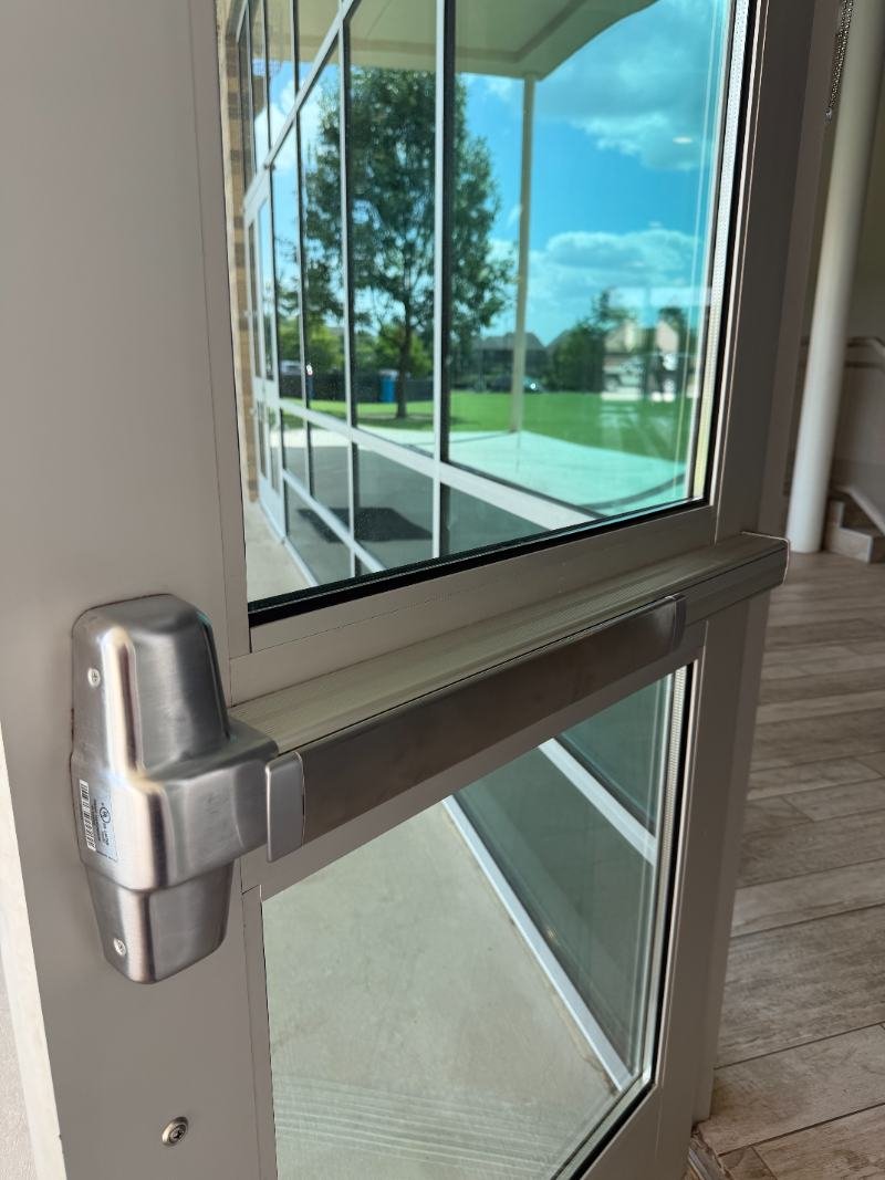 Commercial push bar and panic bar installation on a glass door in Dallas TX